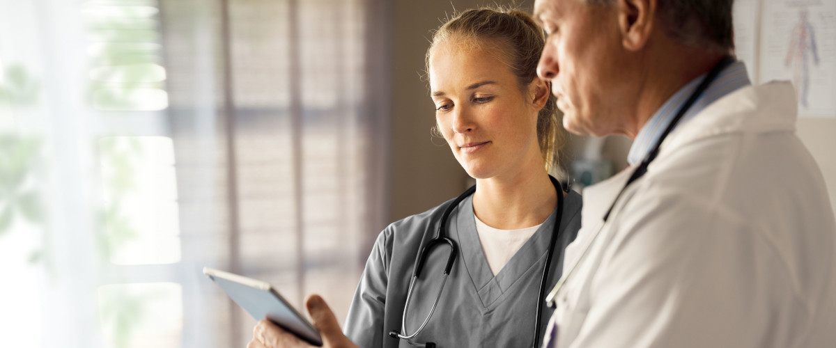 Two doctors looking at a tablet device