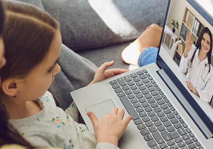 Mother and daughter having a telemedicine call with a doctor on a laptop