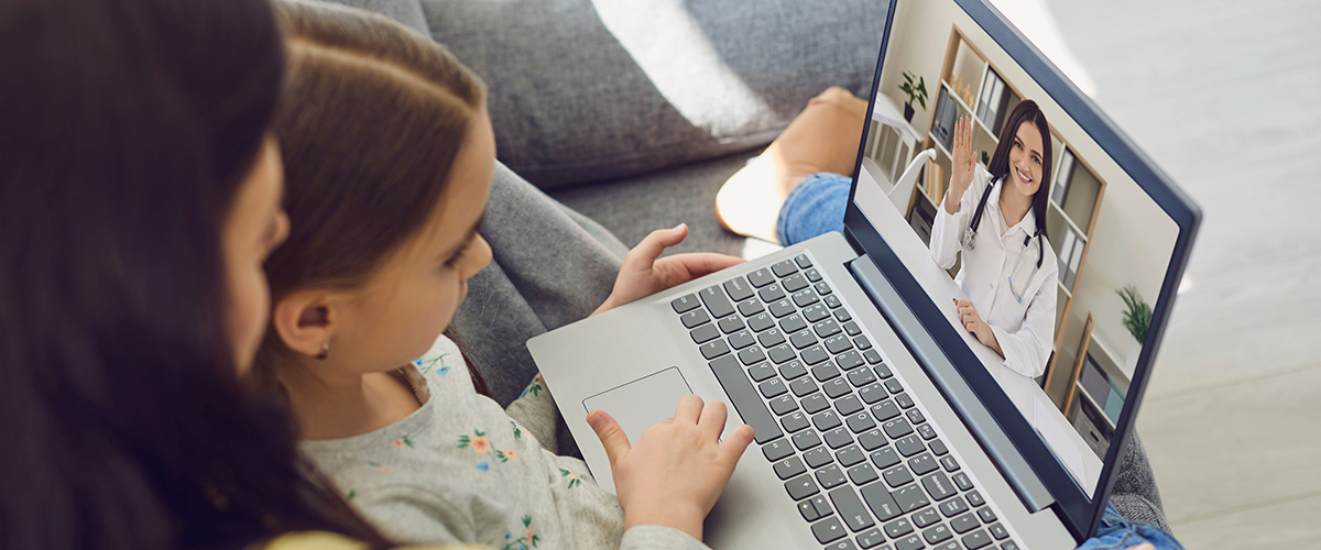 Mother and daughter having a telemedicine call with a doctor on a laptop