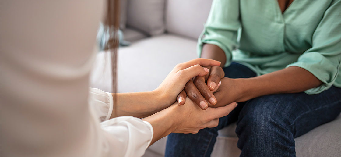 A mental health professional holding hands with a patient