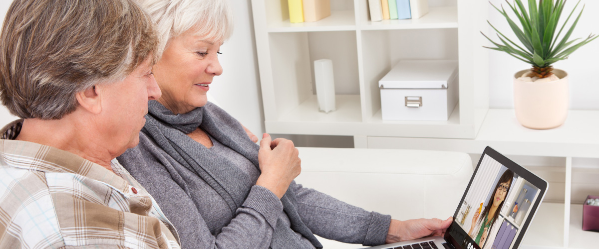 An elderly couple having a virtual care session with a physician.