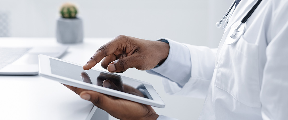 Physician's hands holding a tablet